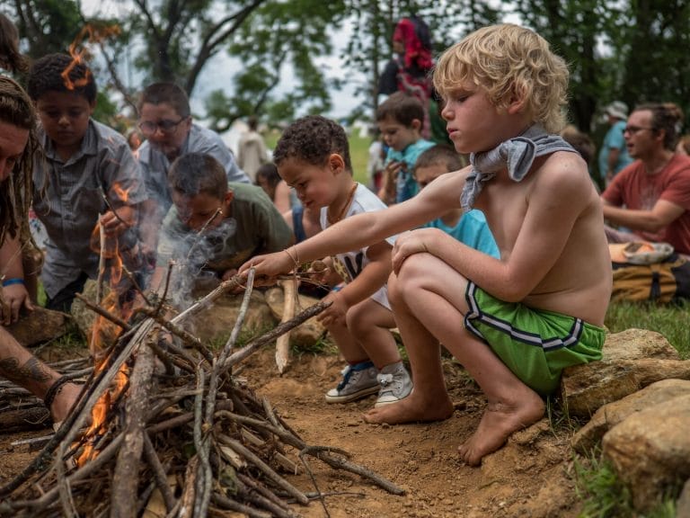 Young boys learning to start a fire