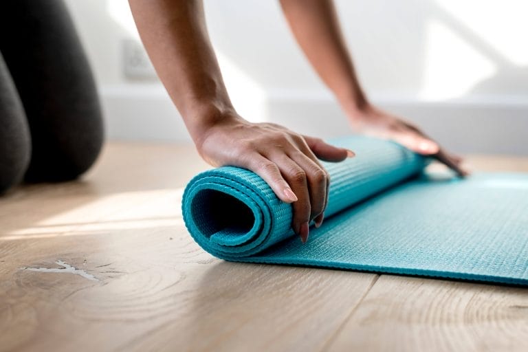 person holding yoga mat
