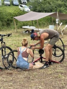 Two people at Firefly Gathering work together to fix a bicycle