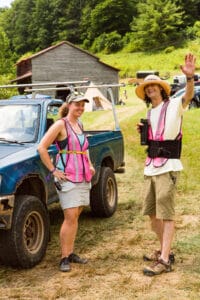 Parking attendants at Firefly Gathering 2024 in a field waving and smiling