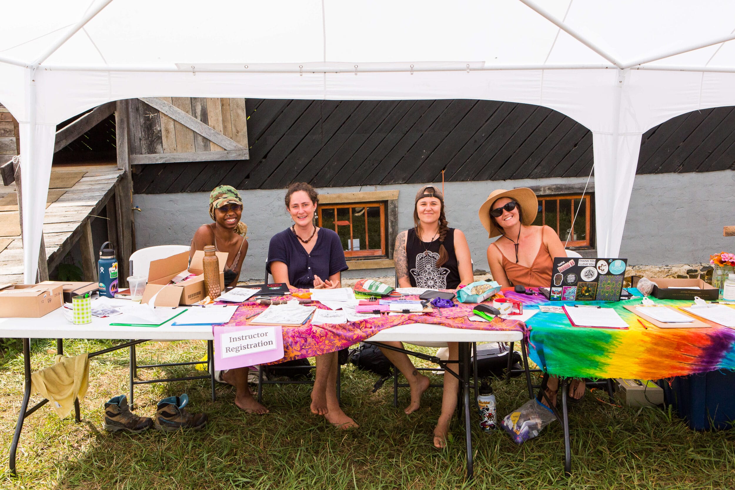 Day in the Life of a Firefly Worktrader 1 Four registration volunteers sit under the registration tent smiling